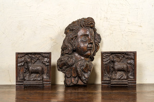 A carved oak cherub's head and a pair of 'Lamb of God' panels, 17th C.