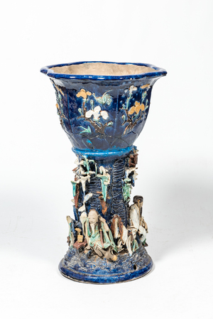 A Chinese polychrome Shiwan pottery jardinière on stand with applied design of scholars, 19th C.