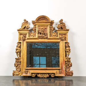 An architecturally carved and gilt wooden mirror with putti, 18/19th C.
