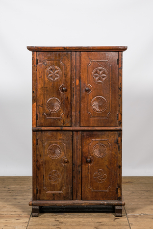 A wooden four-door cupboard with geometrical roundels, Southern Europe, 18/19th C.