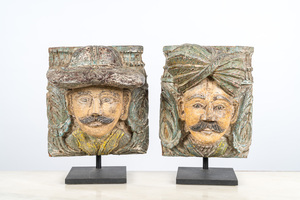 A pair of polychromed wooden heads on metal stands, India, 19/20th C.