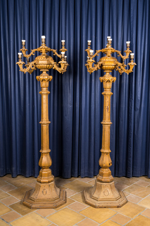 A pair of large patinated wooden and cast iron nine-light candelabra, ca. 1900