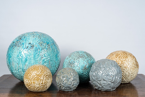 Six glazed terracotta spheres with floral relief design, 20th C.
