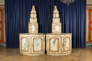 A pair of faux-marbre-painted wooden corner cupboards with a backdrop of shelves, France or Italy, 18/19th C.