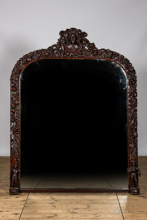A richly sculpted oak wooden mirror, 19th C.
