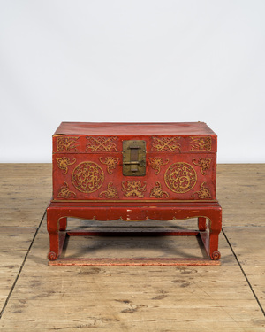 A Chinese red lacquered bronze-mounted travel trunk on foot, 20th C.