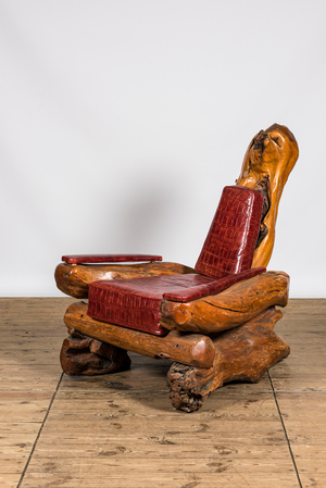 A fauteuil composed of tree trunk fragments with faux-crocodile leather upholstery, 20th C.