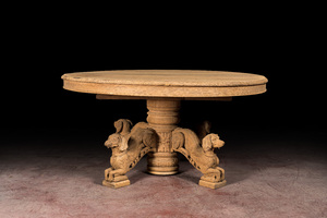 A bleached oak wooden oval table on a richly carved central base with dogs, 19th C.