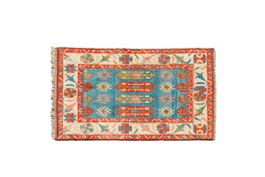 An Oriental woolen rug with floral design and geometric motifs, 20th C.