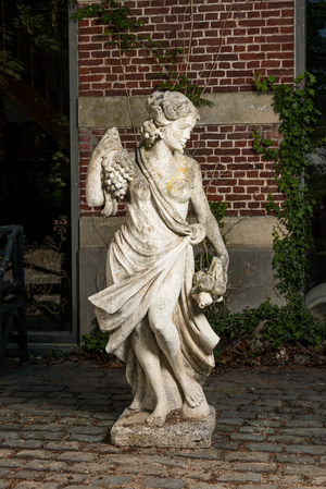 A life size composite stone female allegorical 'autumn' figure with grapes and pomegranates, 20th C.