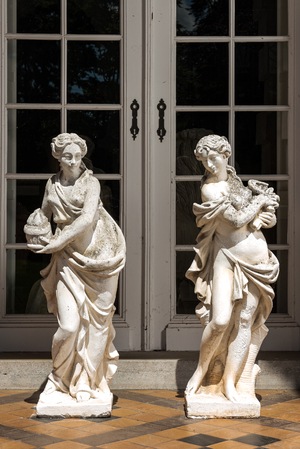 Two large white painted concrete garden statues with allegorical depictions of seasons, 20th C.
