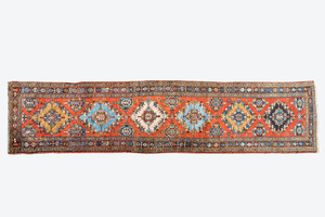 A long Oriental woolen runner with geometric motifs and floral design, 20th C.