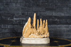 A large stalactites specimen on a painted wooden base
