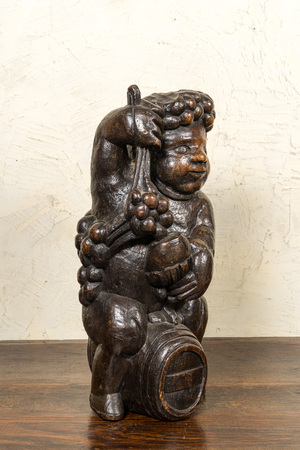 A carved walnut figure of Bacchus on a barrel, 18/19th C.