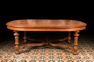 A large oval wooden table on carved baluster-shaped legs, early 20th C.